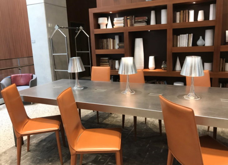 a table with chairs and a shelf with books