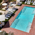 a pool with white umbrellas and chairs