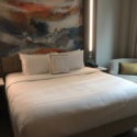 a bed with a painting on the wall