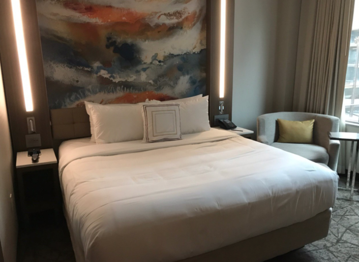 a bed with a painting above it
