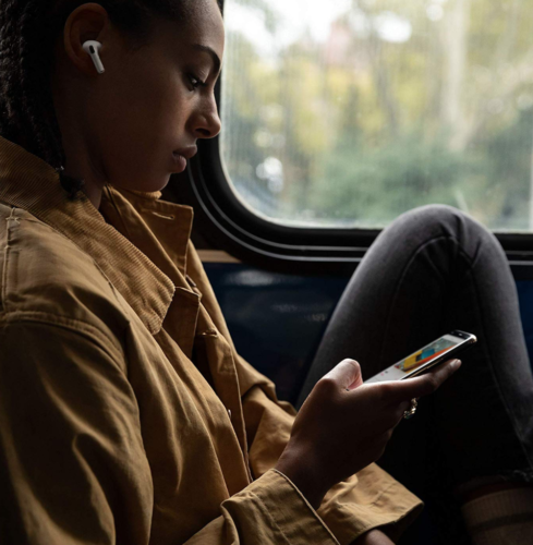 a woman sitting on a bus looking at her phone