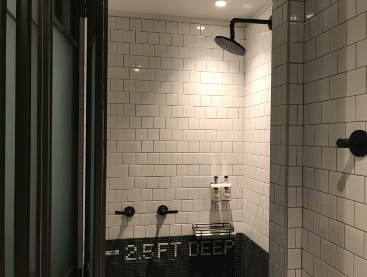 a shower with a black and white tile wall