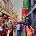 a group of people walking down a street with flags