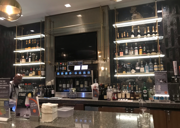 a bar with shelves of liquor and a tv