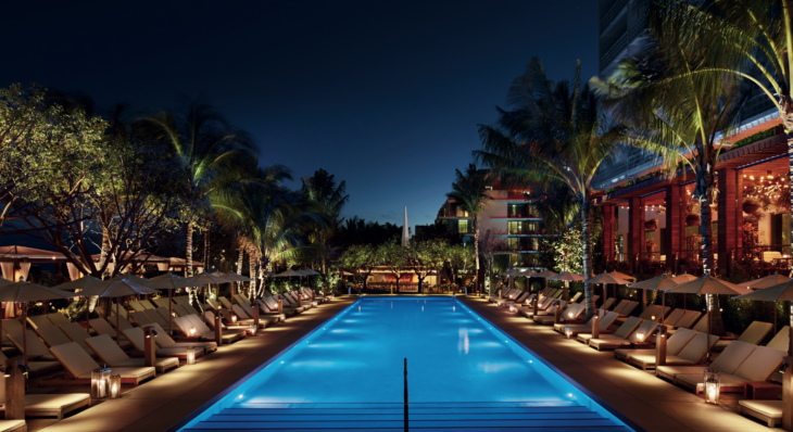 a pool with lounge chairs and palm trees