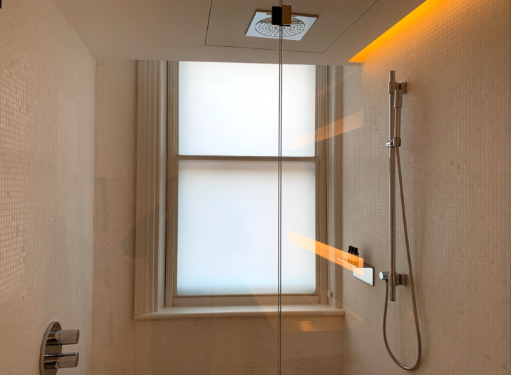 a shower with a window and a shower head