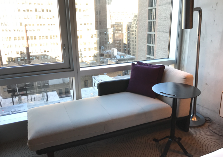 a couch with a table and a round table in front of a window