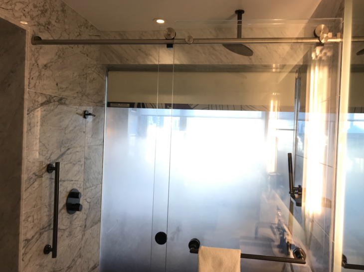 a glass shower door with a towel on a bar