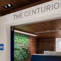 a reception desk with a green wall and a sign