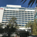 a large white building with trees and cars