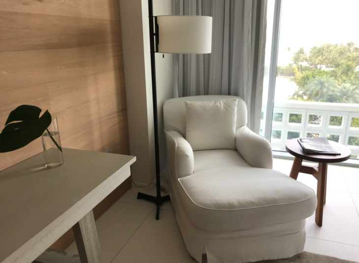 a white chair next to a lamp