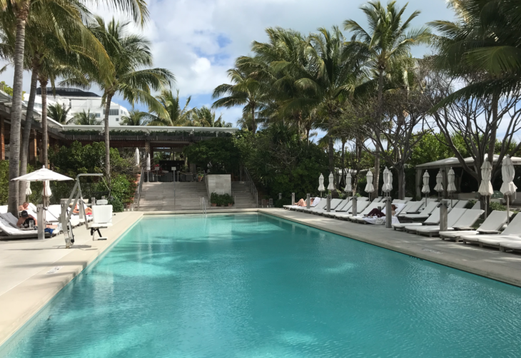 a pool with lounge chairs and palm trees