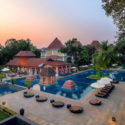 a pool with lounge chairs and umbrellas in a resort