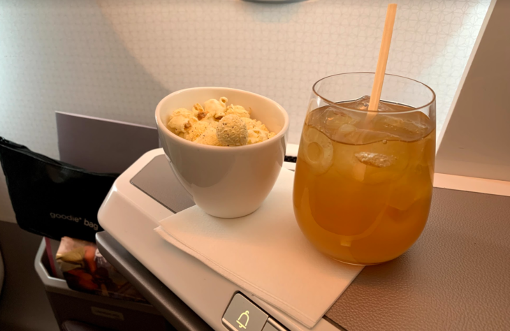 a bowl of popcorn and a drink on a tray