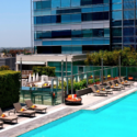 a pool with lounge chairs and a building in the background