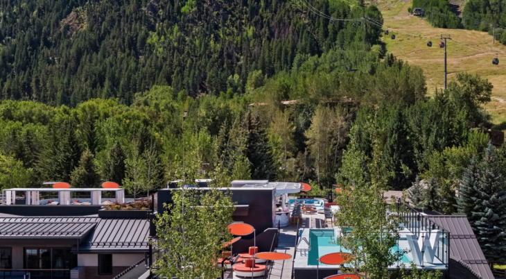 a rooftop of a building with a pool and trees in the background