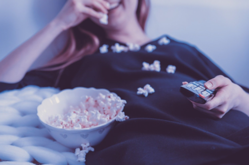 a woman lying down with popcorn on her chest