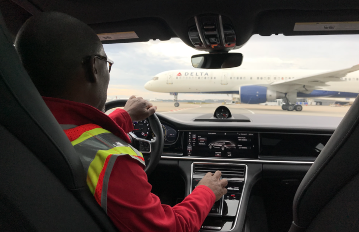 a man in a car with a yellow vest and a red vest