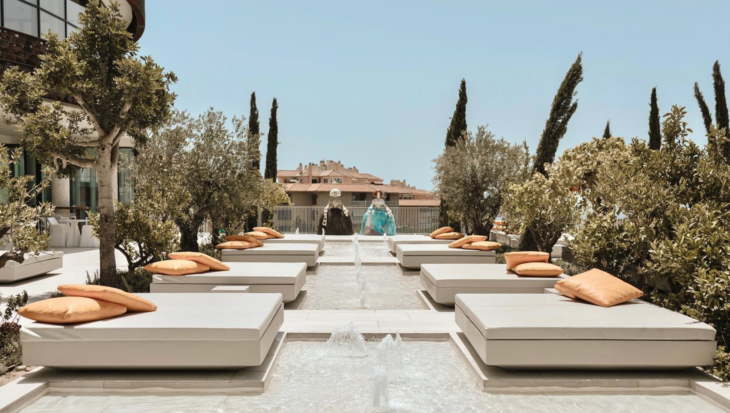 a pool with white benches and water fountain