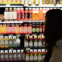 a woman standing in front of shelves of drinks