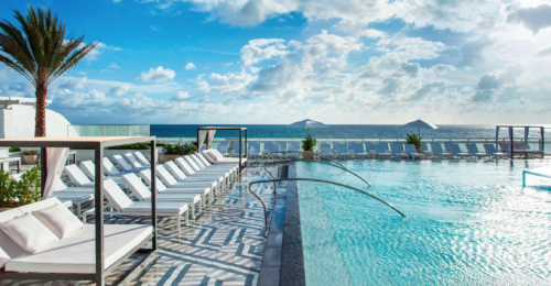 a pool with chairs and a large body of water