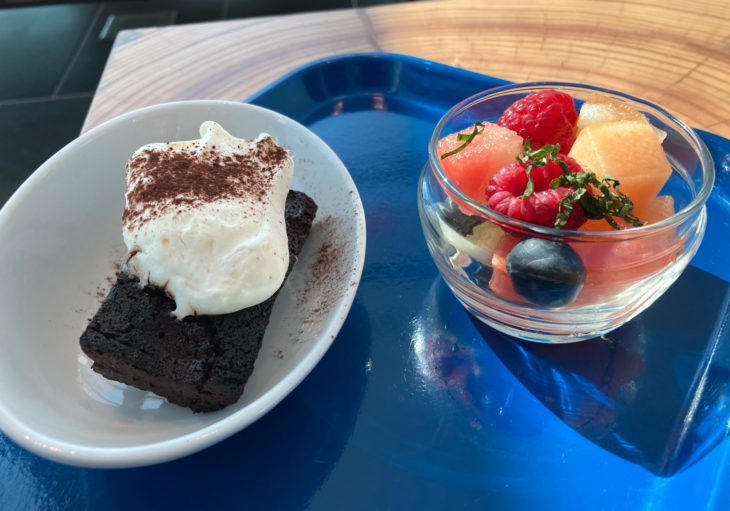 a plate of dessert and fruit on a tray