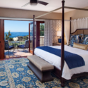 a bedroom with a four poster bed and a blue and white rug