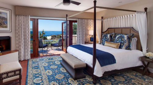 a bedroom with a four poster bed and a blue and white rug