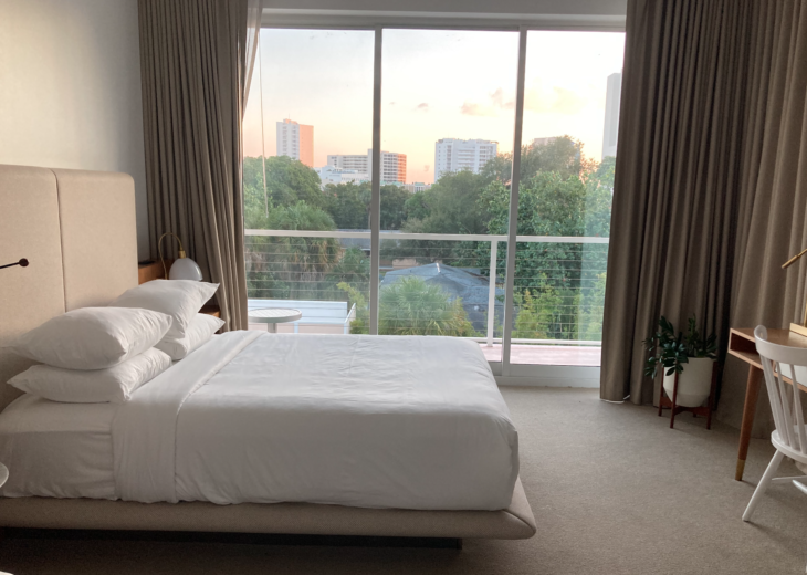 a bed with a view of trees and a balcony