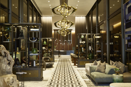 a lobby with a chandelier and shelves