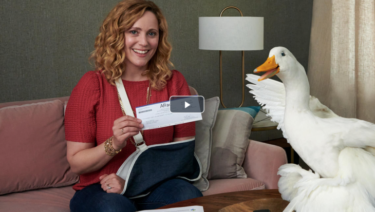 a woman holding a check and a duck