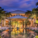 a building with a pool of water and palm trees