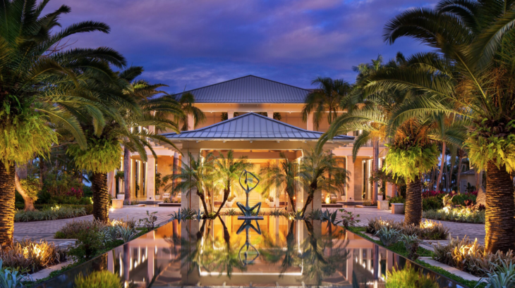 a building with a pool of water and palm trees