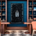 a room with a black framed artwork on the wall and shelves