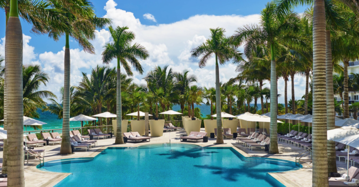 a pool with palm trees and chairs