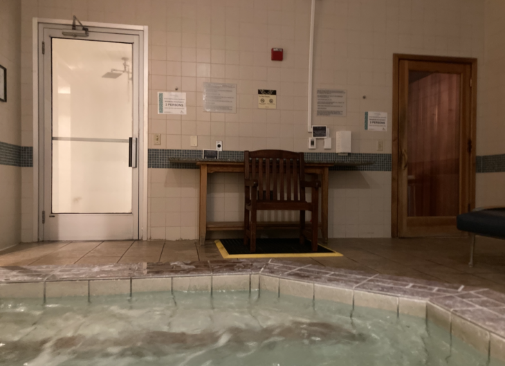 a wooden chair in a room with a hot tub