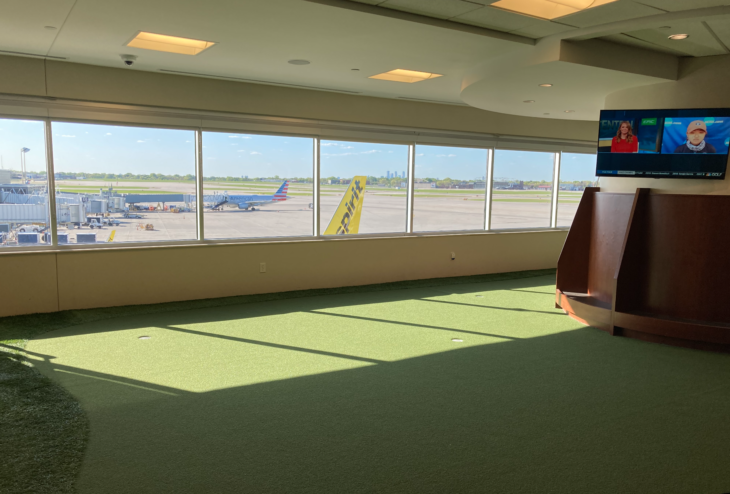 a room with a large window and a green carpet