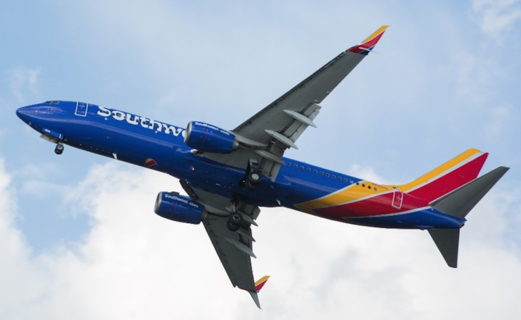 a blue and red airplane flying in the sky