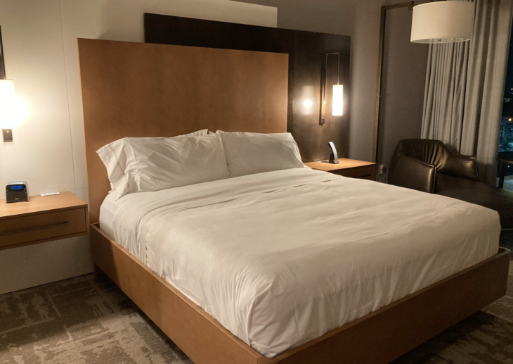 a bed with a wood headboard and lamp