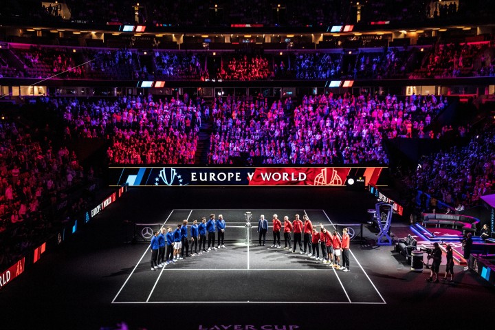 a group of people standing on a tennis court