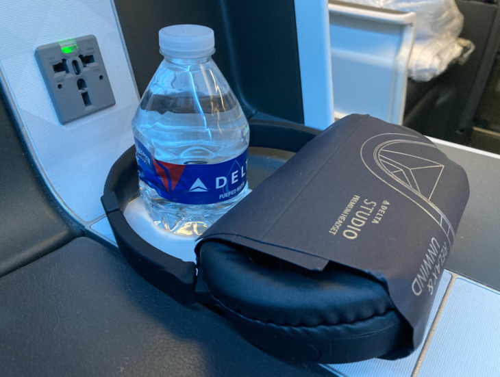 a water bottle and headphones on a seat