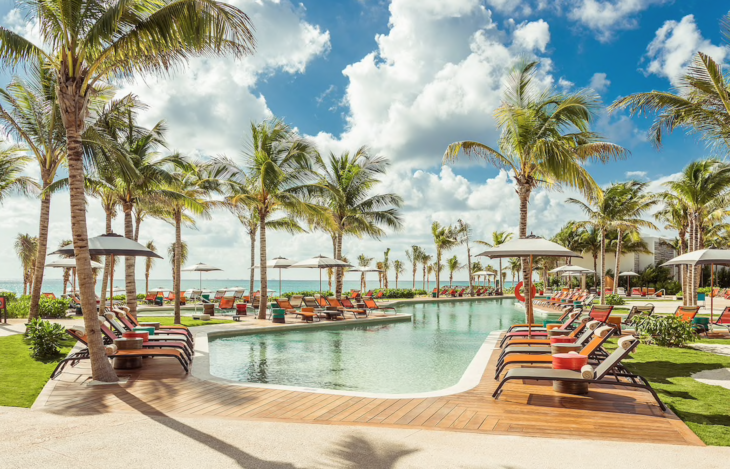 a pool with lounge chairs and umbrellas