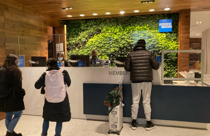 people standing in front of a green wall