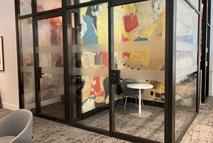 a glass doors with a table and chair in front of a colorful wall