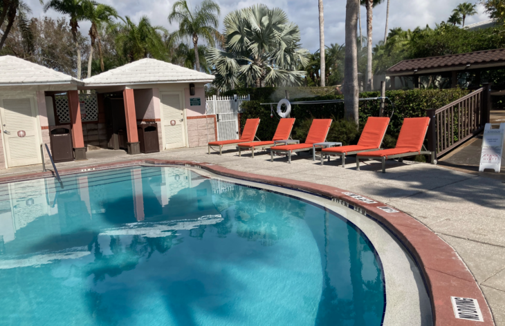 a pool with lounge chairs and a building