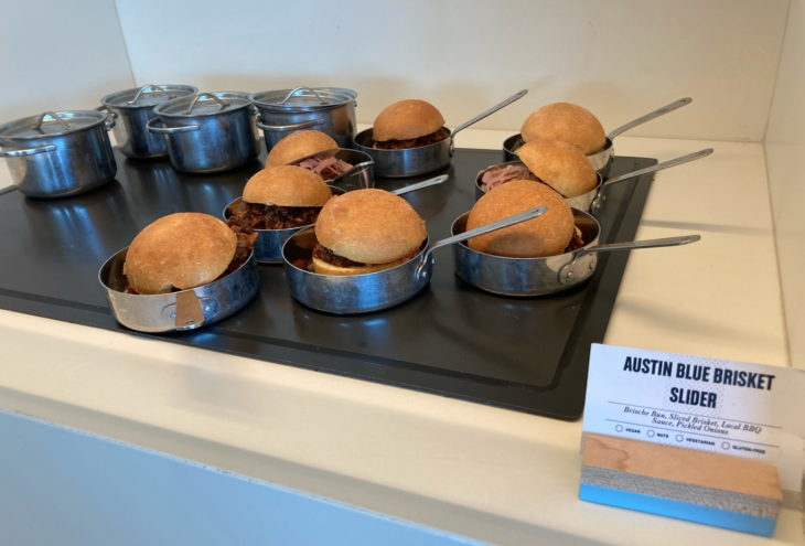 a group of sandwiches in small pans on a black surface