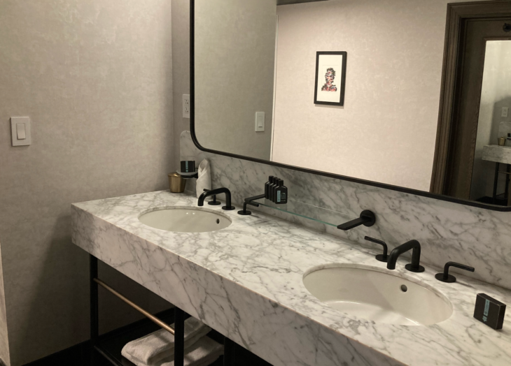a bathroom with a marble countertop and a large mirror