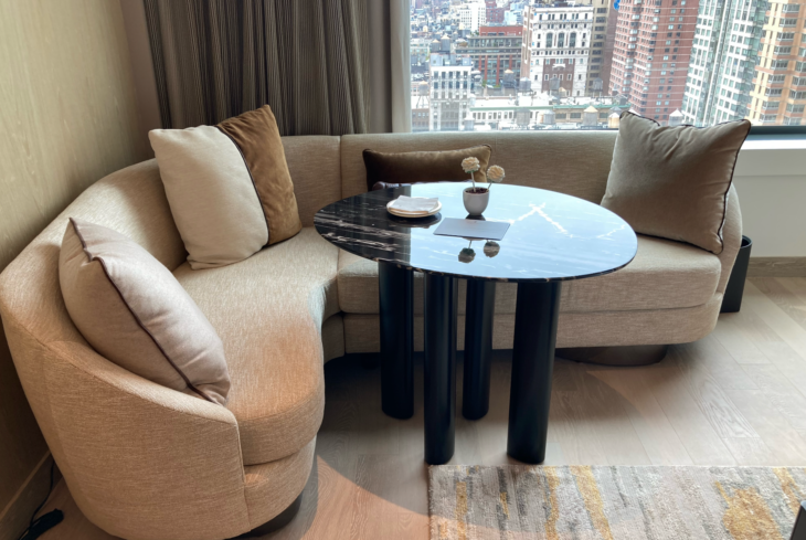 a couch with a table and a window with city view