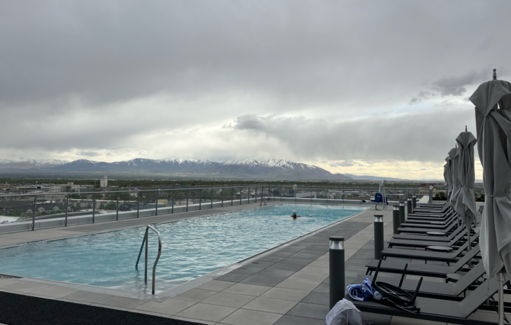 a pool with chairs and a mountain in the background