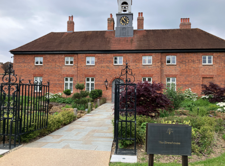 a brick building with a clock tower with Jane Austen's House Museum in the background